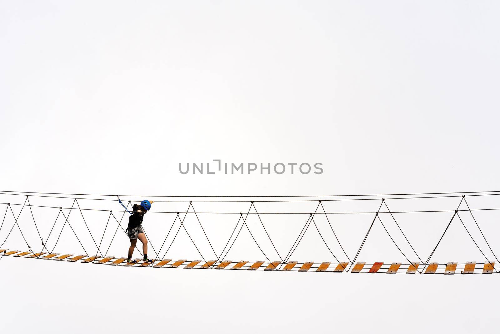 Man crossing rope bridge over the abyss in foggy mountains in Russia