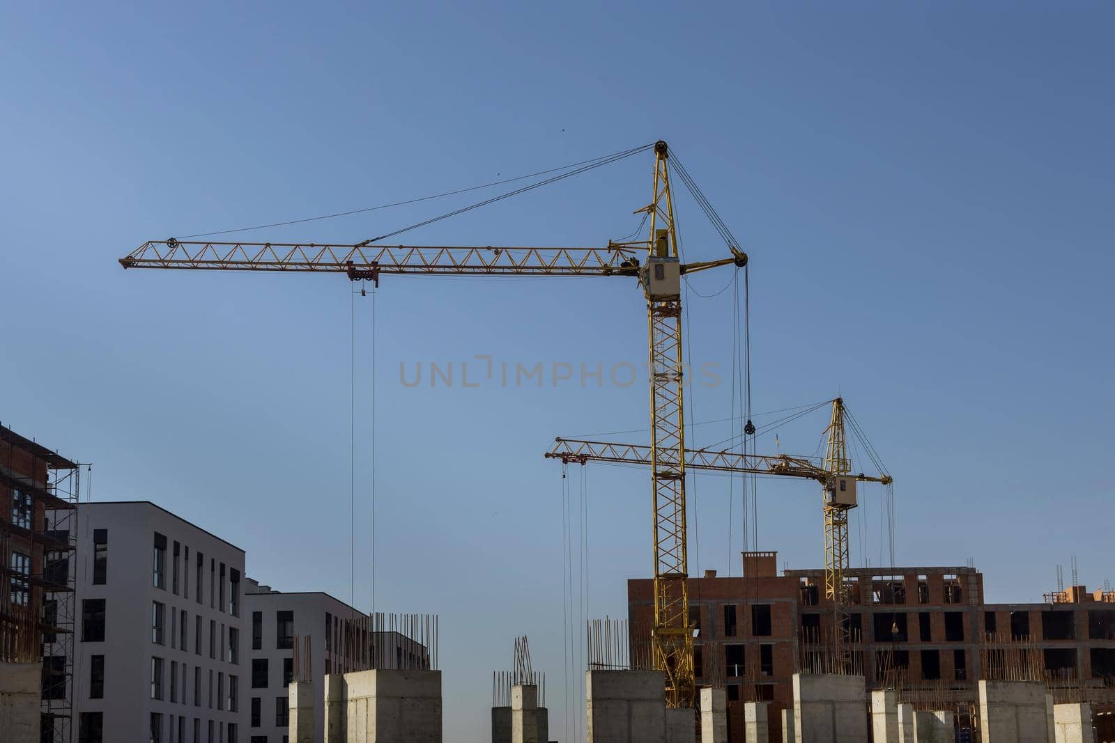 Aerial view with high rise building under construction at tower cranes by ungvar