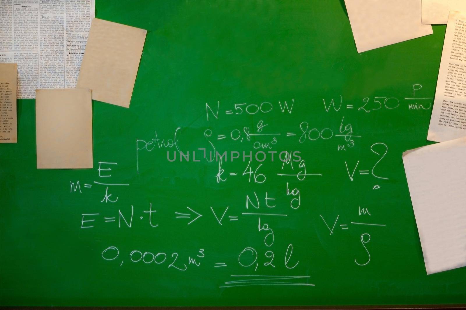 math formulas and papers on a green board - blackboard and school concept. teaching physics