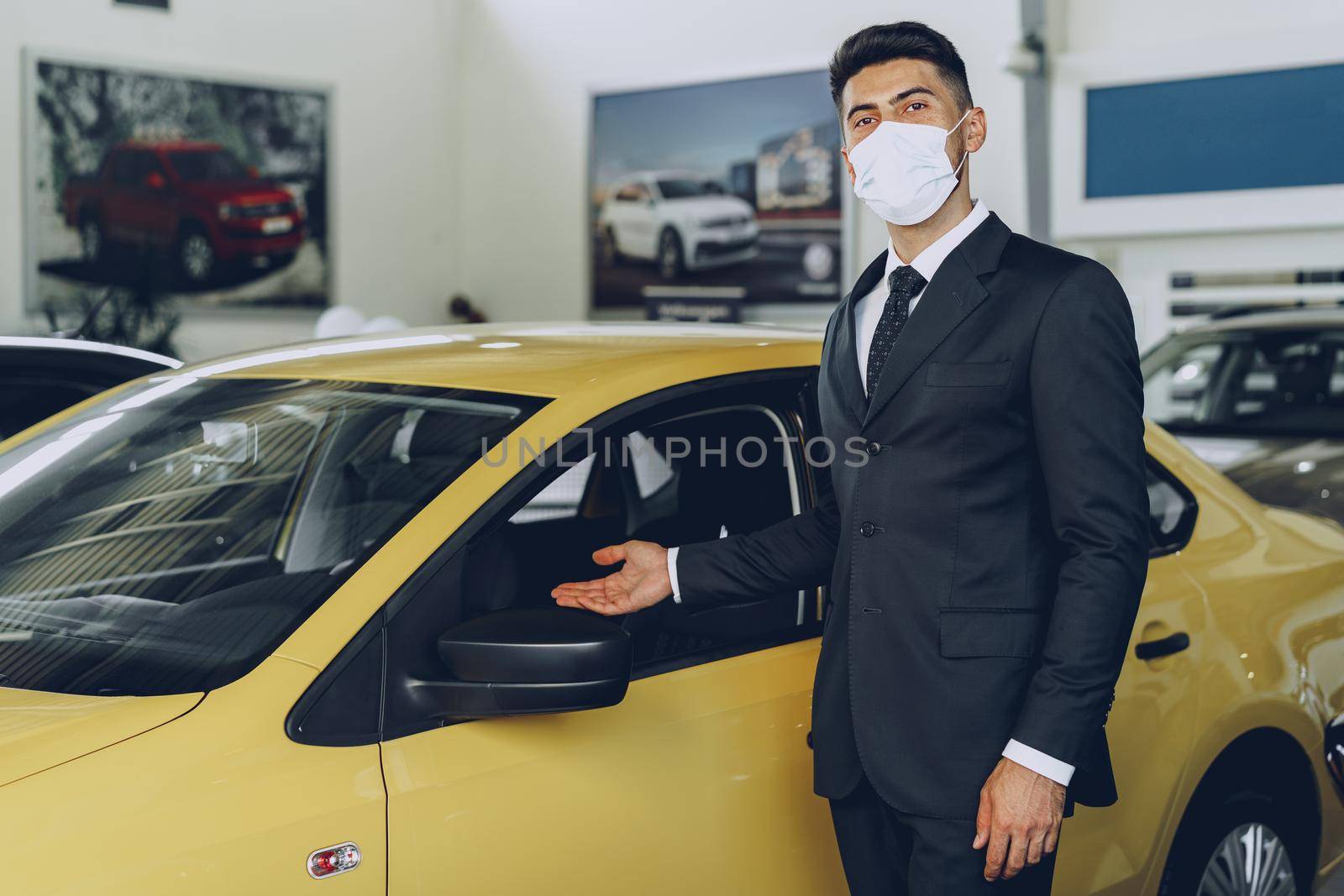 Man car dealer wearing protective medical mask on his working place, coronavirus prevention concept