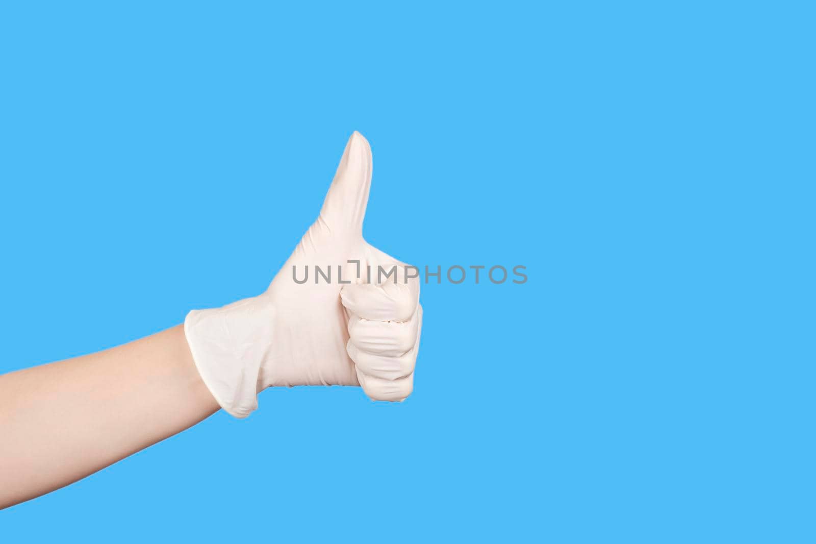 Hand gesture. Hand in a white latex glove showing thumbs up sign isolated on white background. Copy space