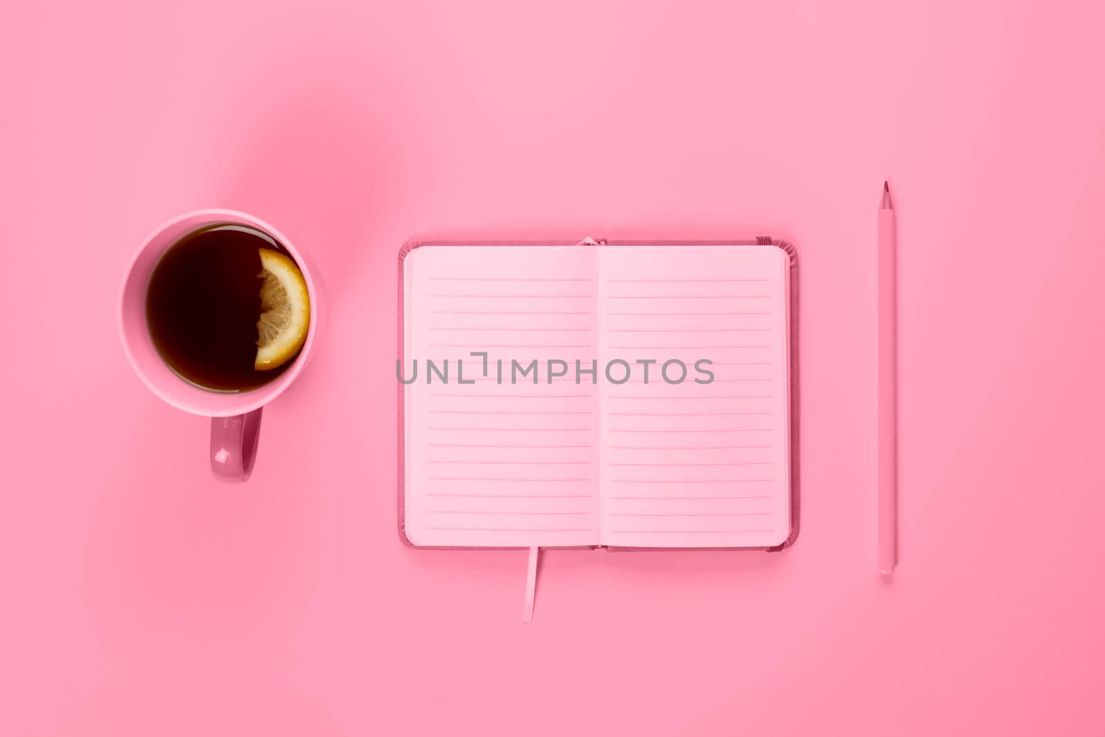 Tea cup and fancy notebook with empty or blank page on desk from above, planning and design concept. Top view, flat lay, copy space. Mock up toned in pink.