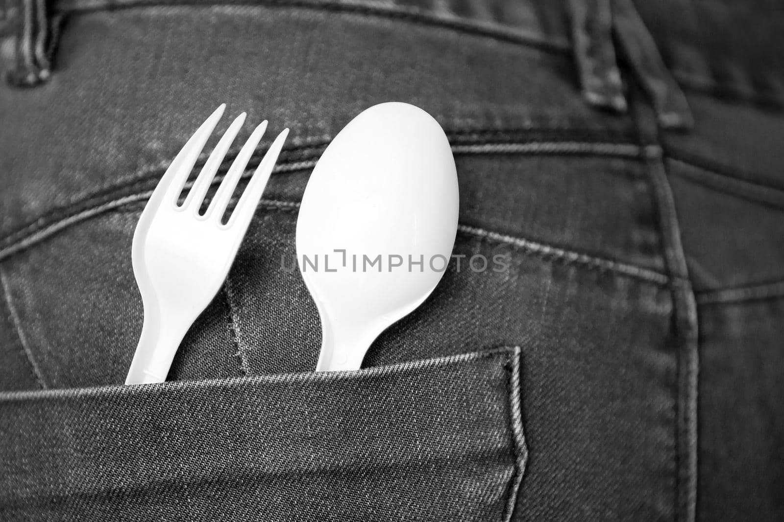 reusable plastic spoon and fork at the pocket. safe environment. Take Out Food Concept with Denim Jeans with a white Fork and Spoon in the Pocket. fast food concept.