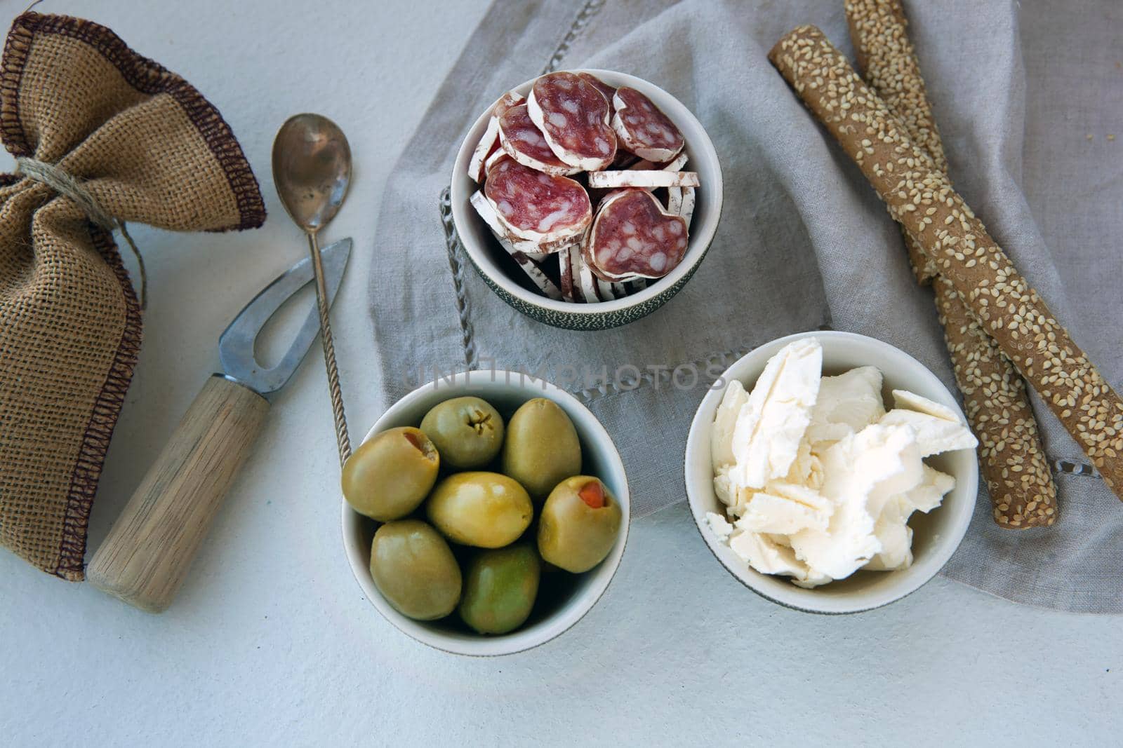 Antipasto catering platter with different meat and cheese products. cheese, olives and ham for a simple breakfast. linen napkin and small knife