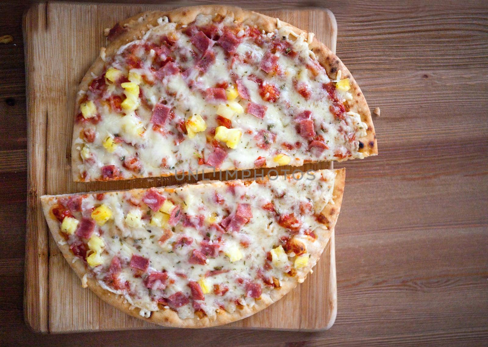 Cuttedhomemade pizza slices. Delicious italian pizza served on wooden table