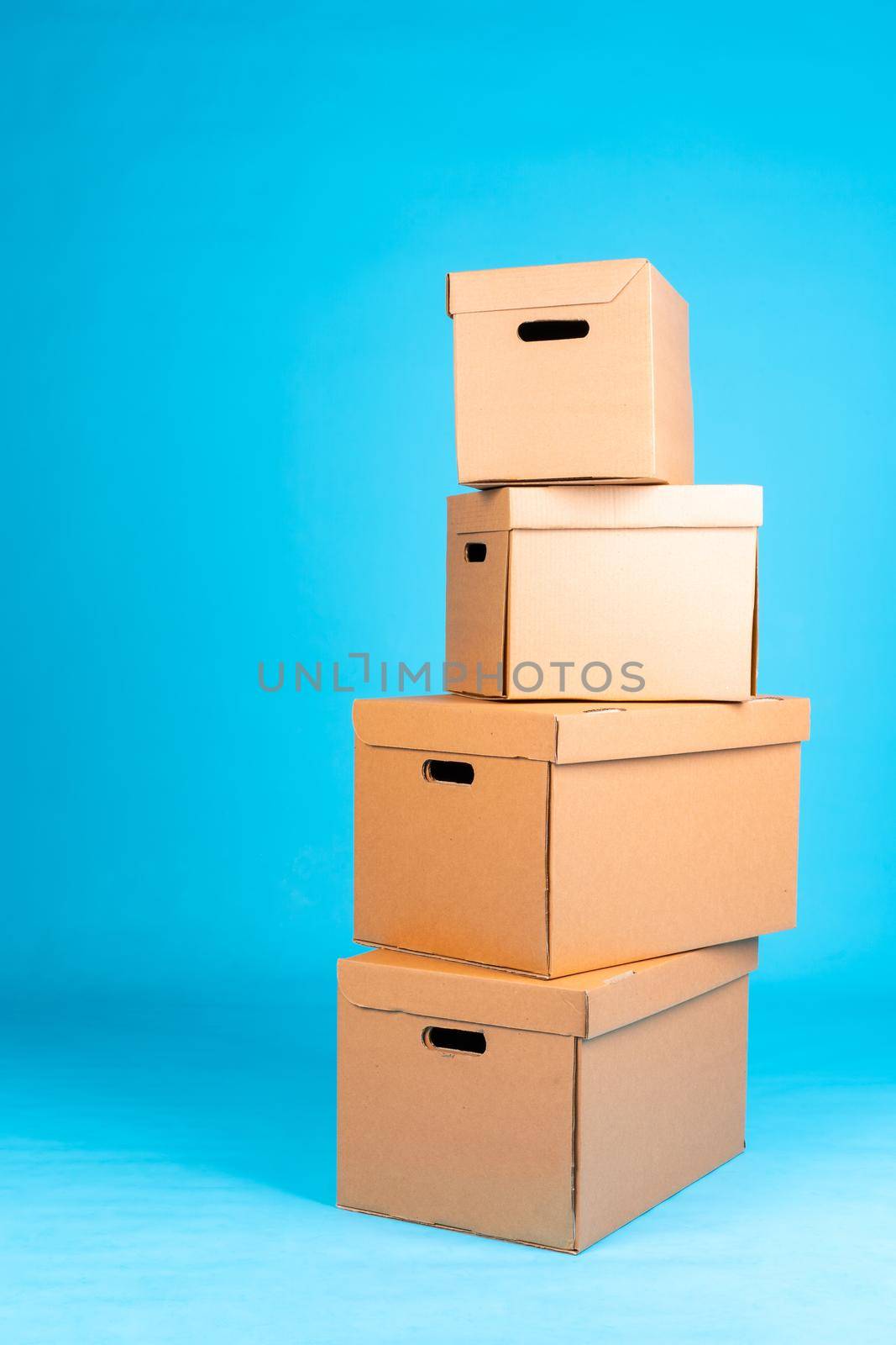 Stack of cardboard boxes on blue background. Close up.