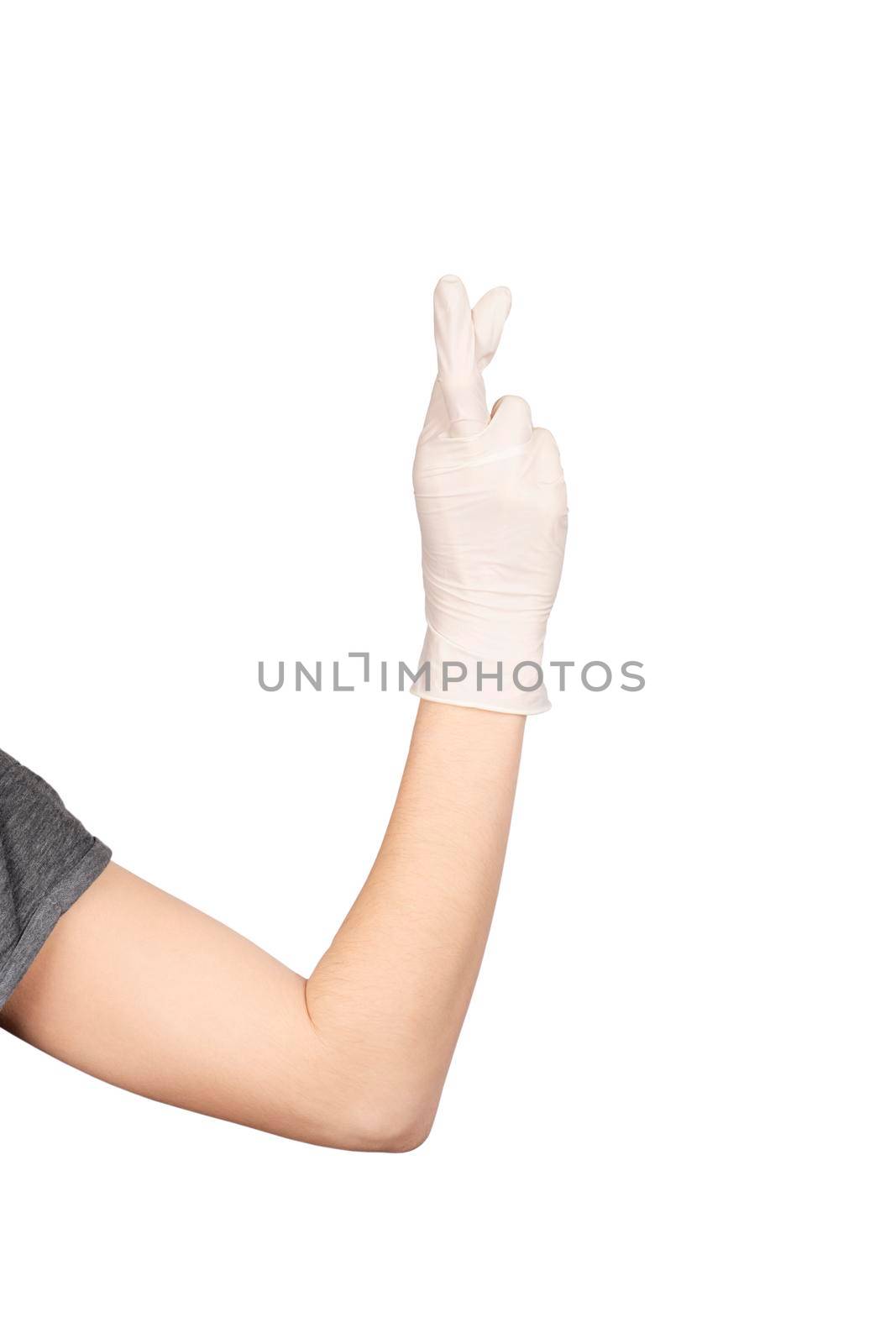 Hand gesture. Hand in a white latex glove showing fingers crossed sign isolated on white background. Hope concept