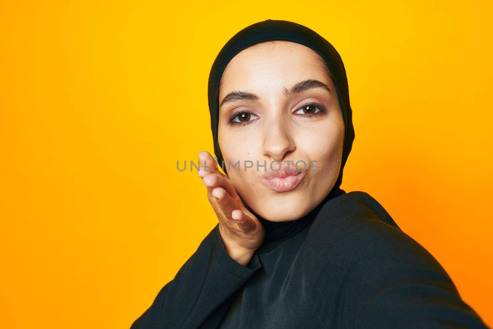 Muslim in black hijab posing fashion hand gesture isolated background by Vichizh
