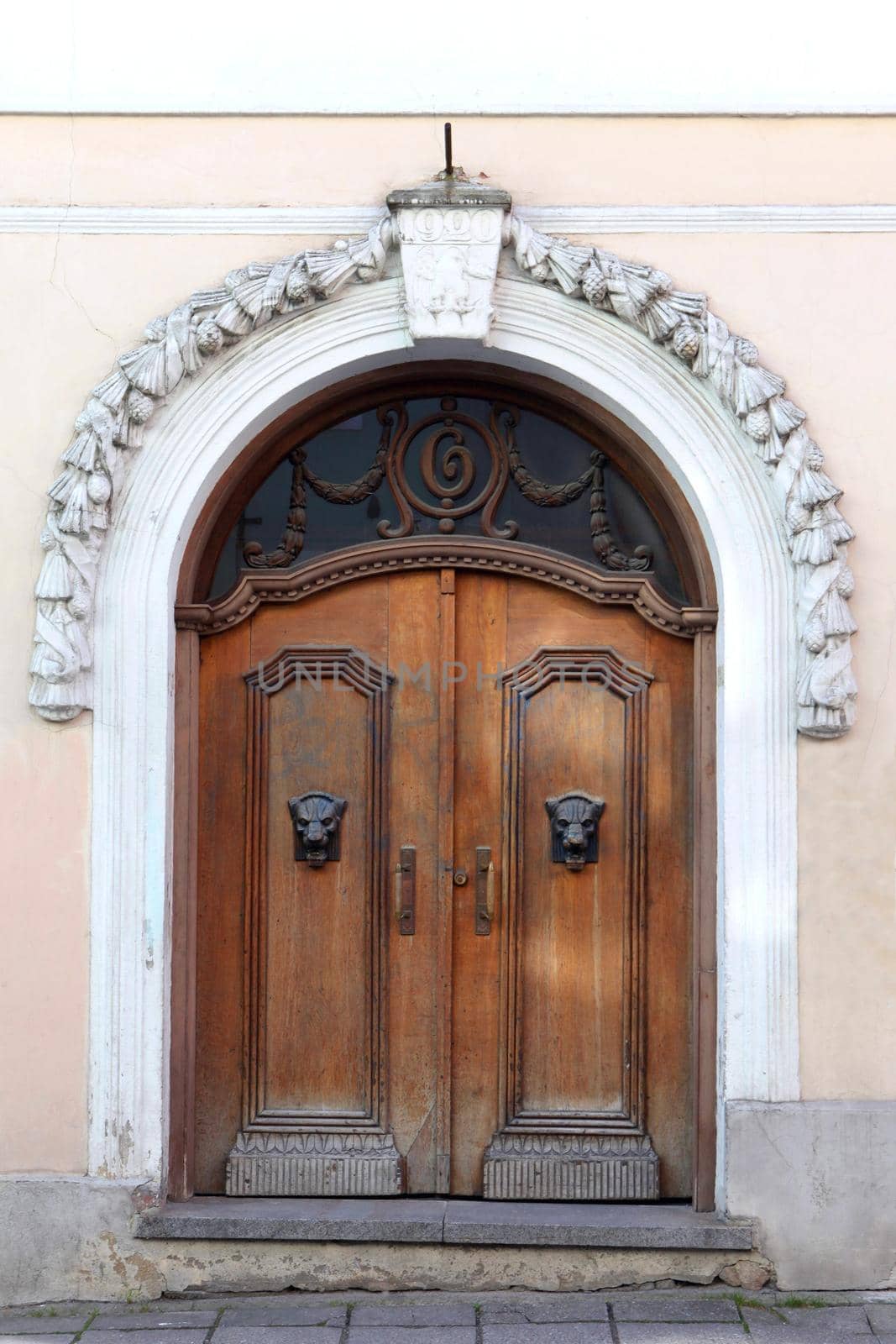 Wooden gates or doors with decoration elements in old building facade. Tallinn, Estonia. big wooden brown antique timber antique doors, stone walls and massive gates