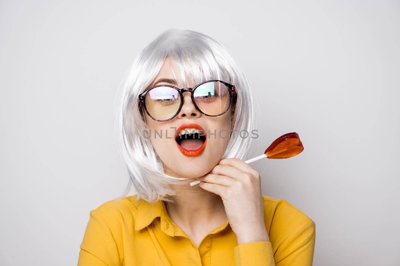 attractive woman with glasses white wig lollipop fashion glamor. High quality photo