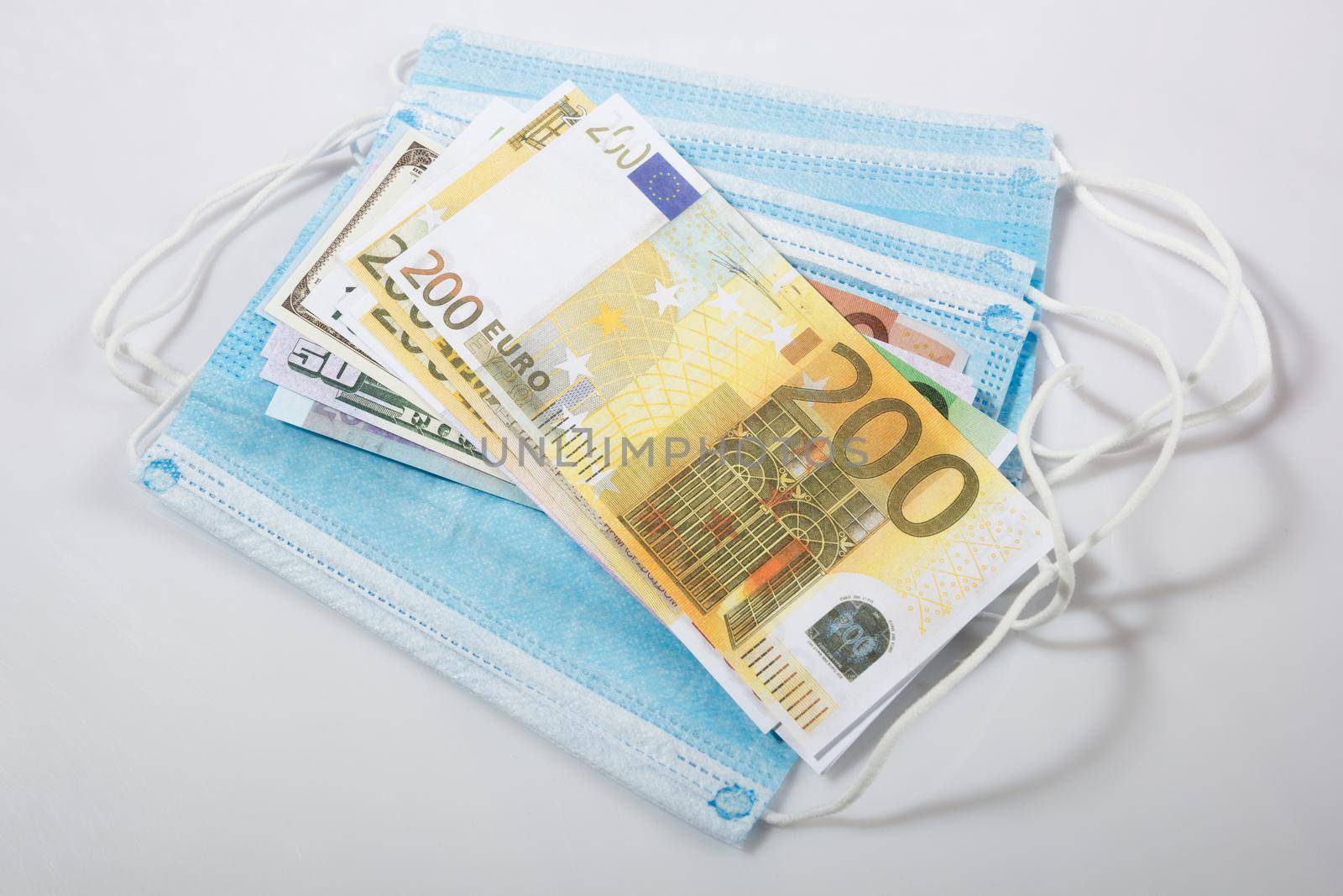 disposable hygienic mask and euro banknotes on gray background