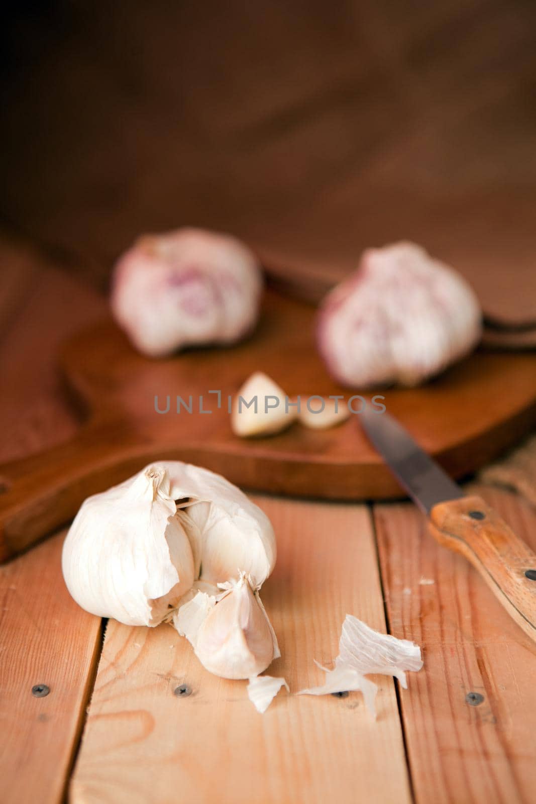 Garlic cloves and garlic bulb on a white wooden table. rustic style organic food - garlic on wooden table