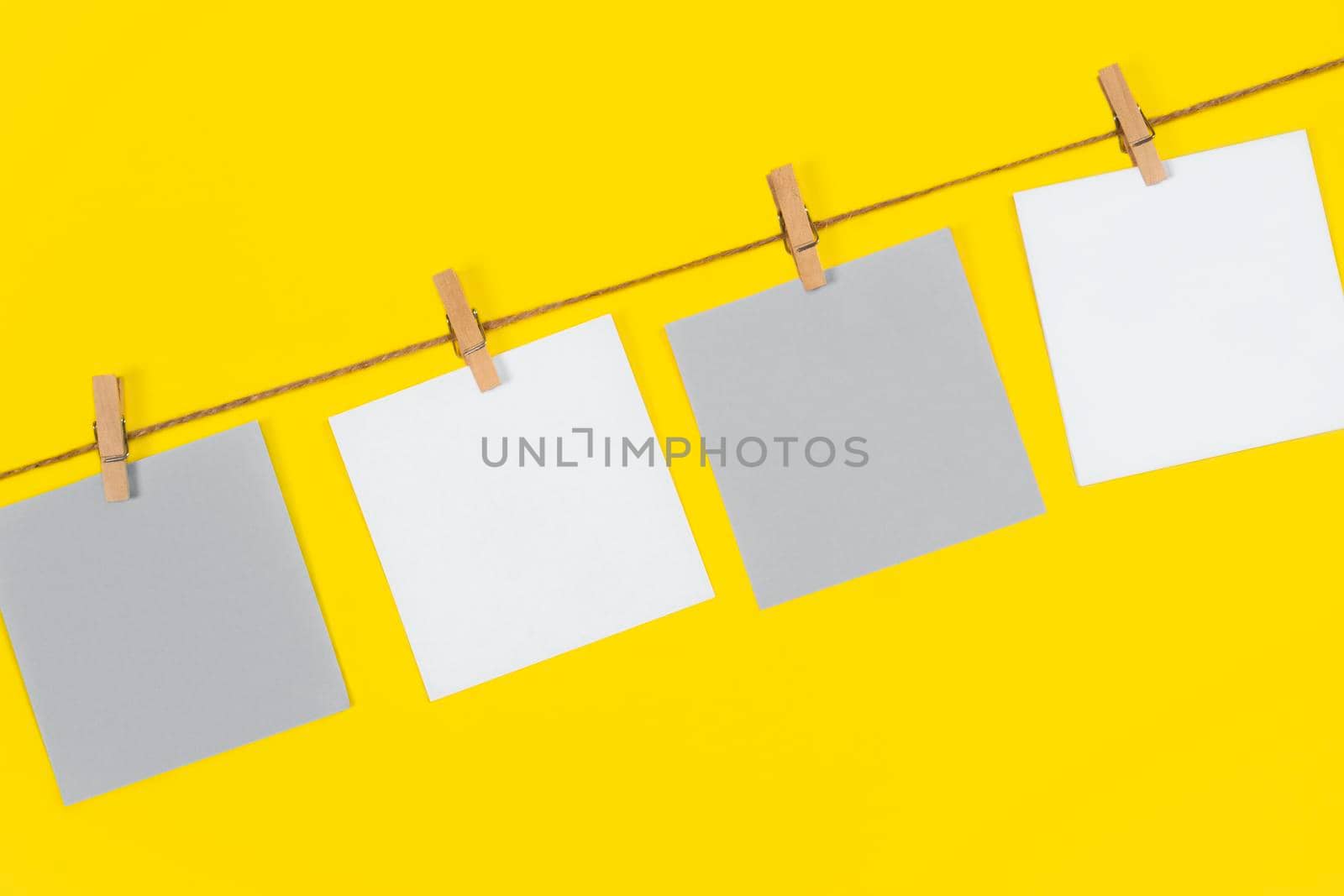 Note papers and decorative pin or clip isolated on yellow background. Office mock up. Top view, flat lay. Colorful office note or sticker papers