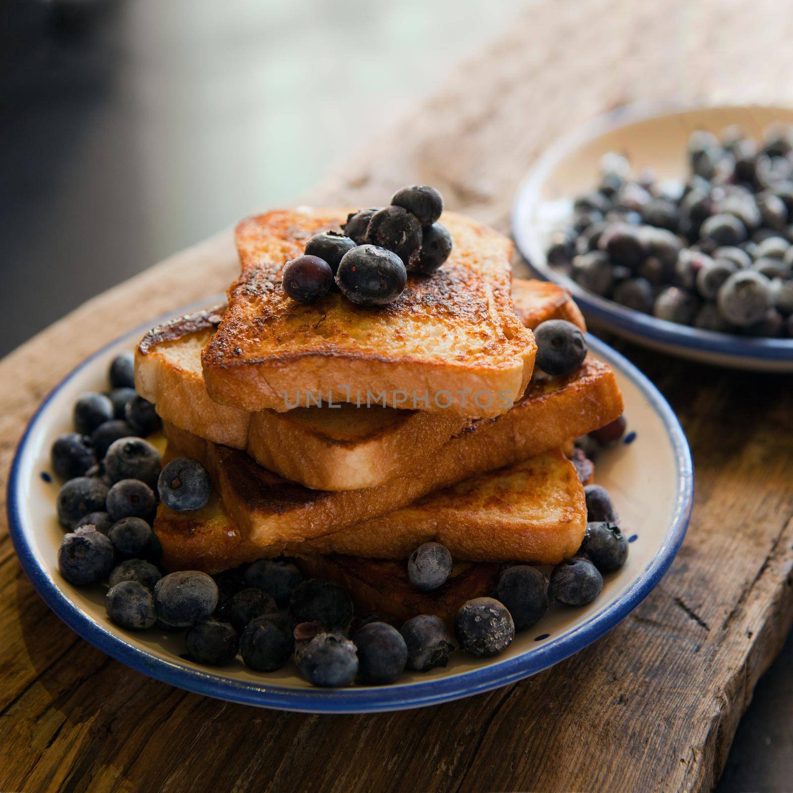 French toast with berries blueberries, strawberries and sauce, traditional sweet dessert of bread with egg and milk. Morning baking food. toasted bread with bluberries