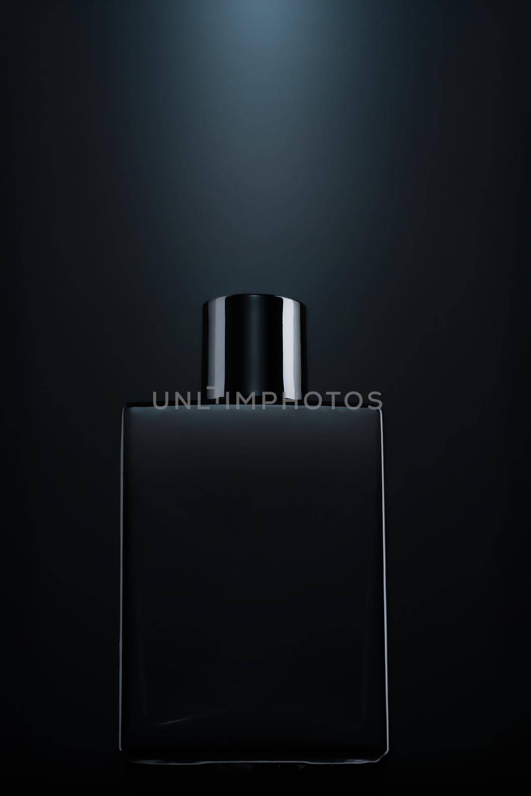 Silhouette of a black bottle of eau de toilette for men on a dark background. Advertising photo of perfumes. Dark style by SergeyPakulin