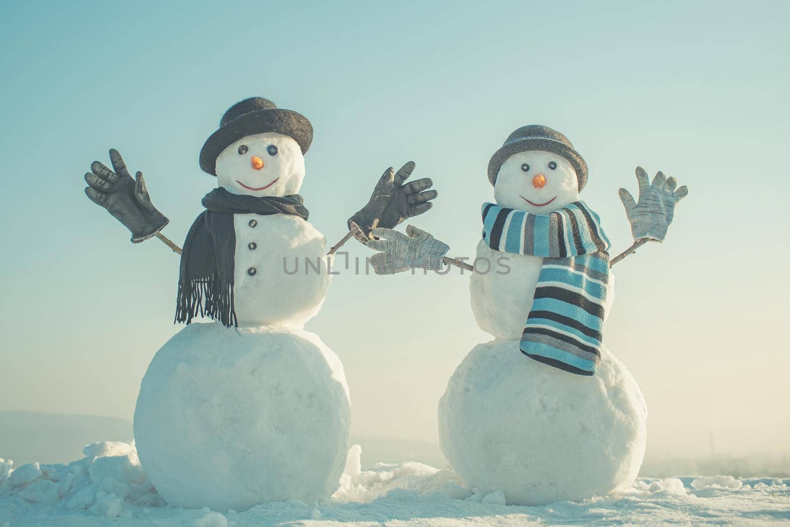 Snowman with hat and scarf in winter outdoor. Happy winter holiday card