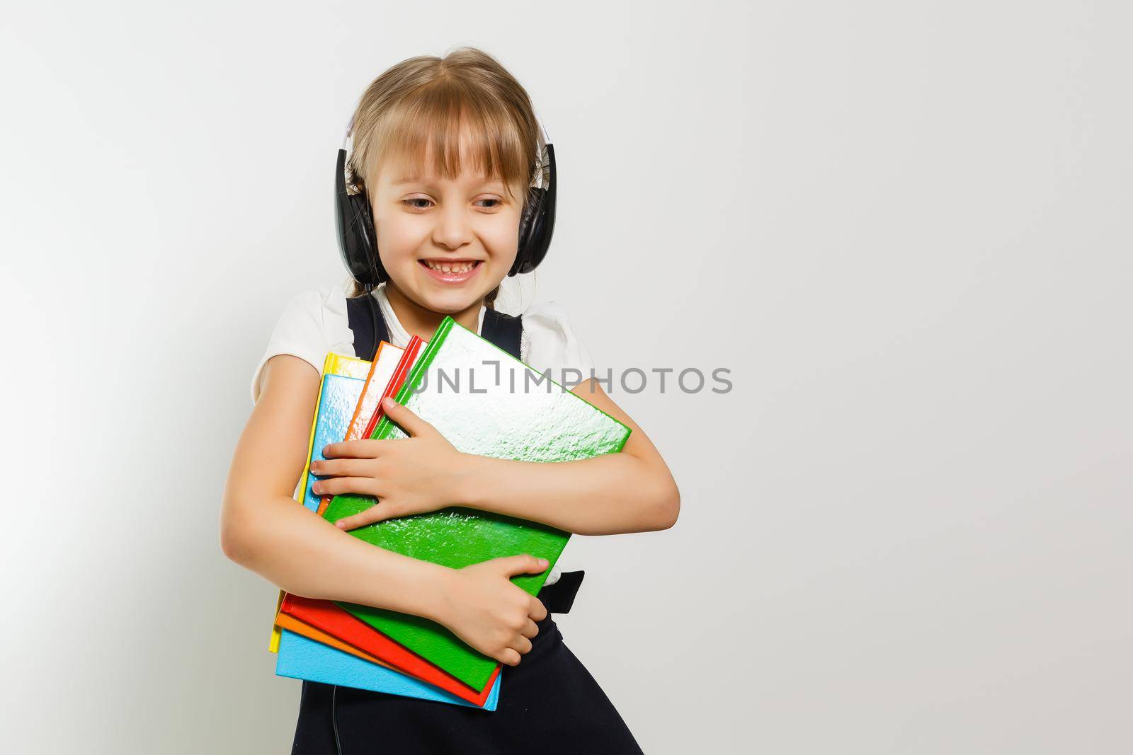 Little Funny girl in shirt with books. Isolated on white background. Baby girl in school. The child girl with textbooks. Girl studing.