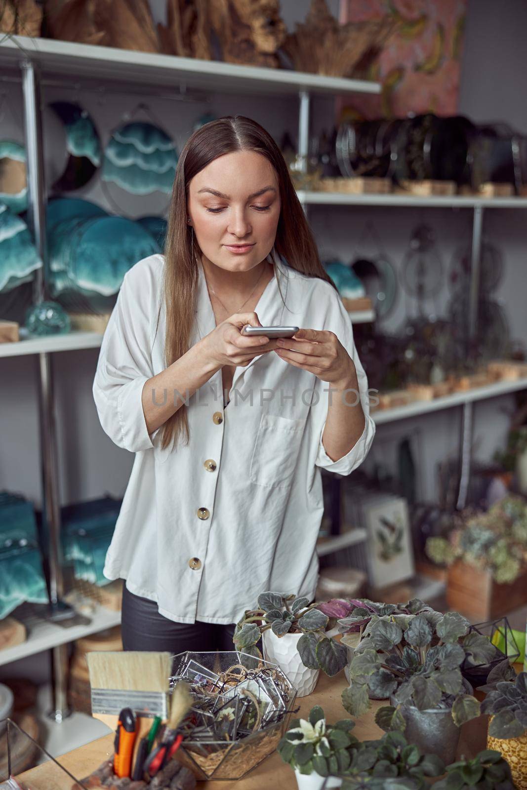 Young caucasian happy seller woman at botanic shop