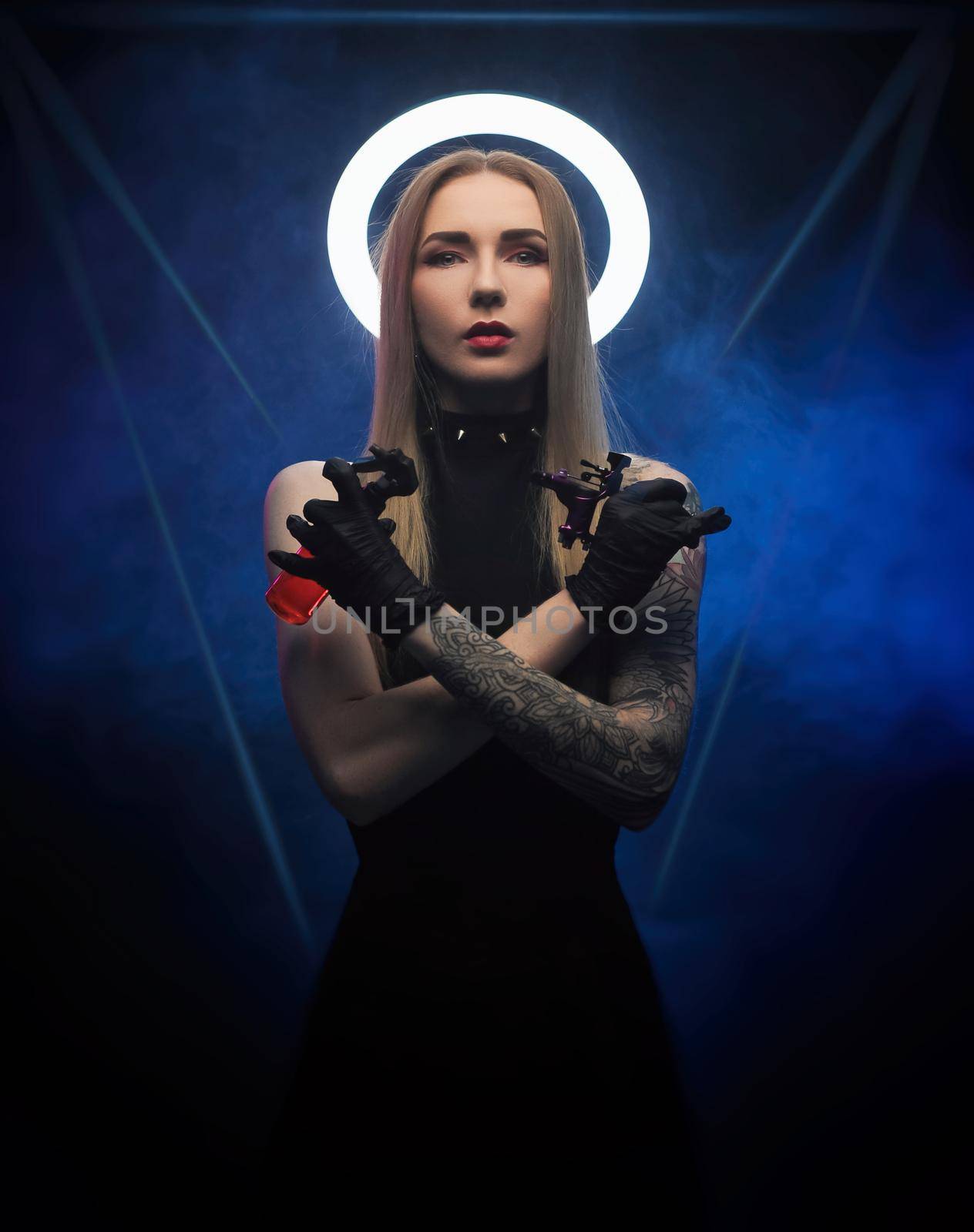 a woman with a halo in black clothes with a tattoo machine by Rotozey