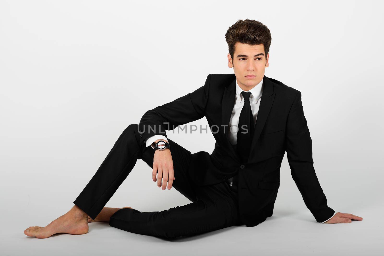 Portrait of a young businessman wearing a suit, barefoot, isolated on white background