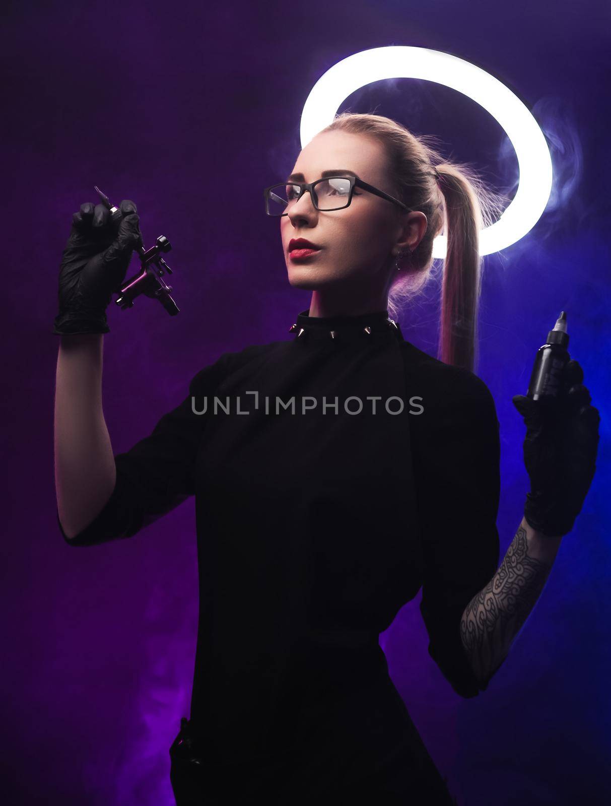 the woman with a halo in black clothes with a tattoo machine
