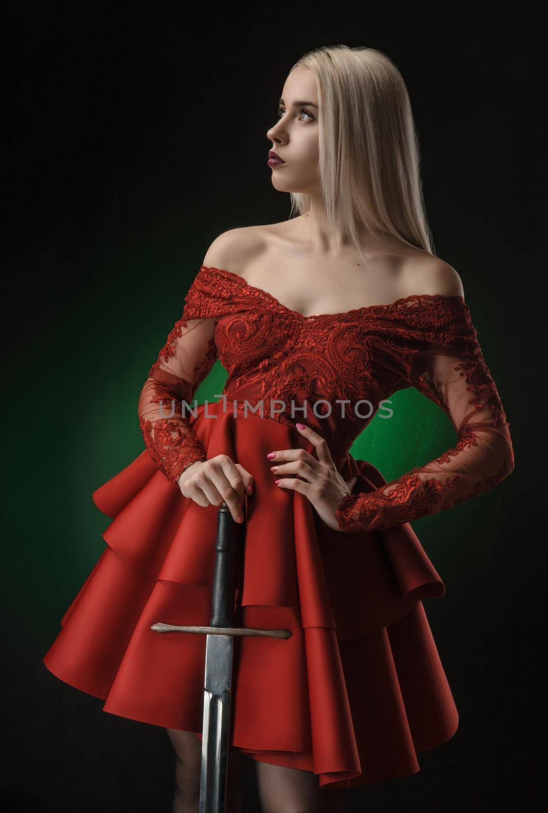 lovely girl in red dress with sword posing on black background in Studio (blonde )