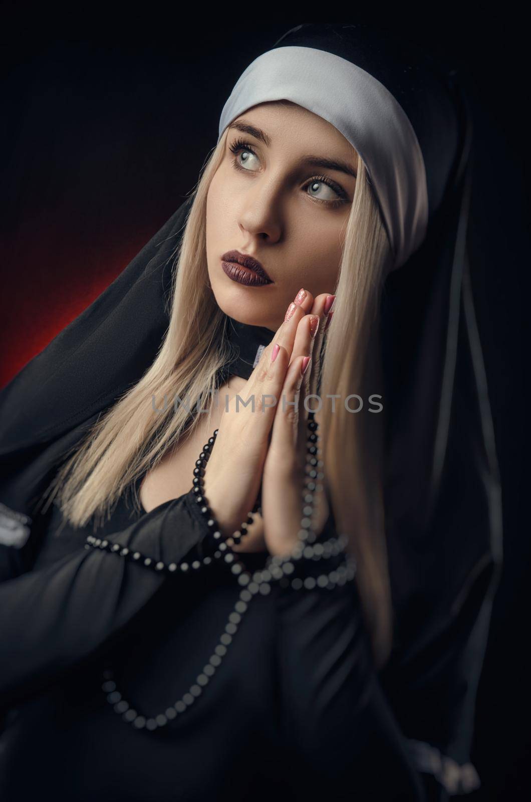 Fine art portrait of a novice nun in deep prayer with rosary by Rotozey