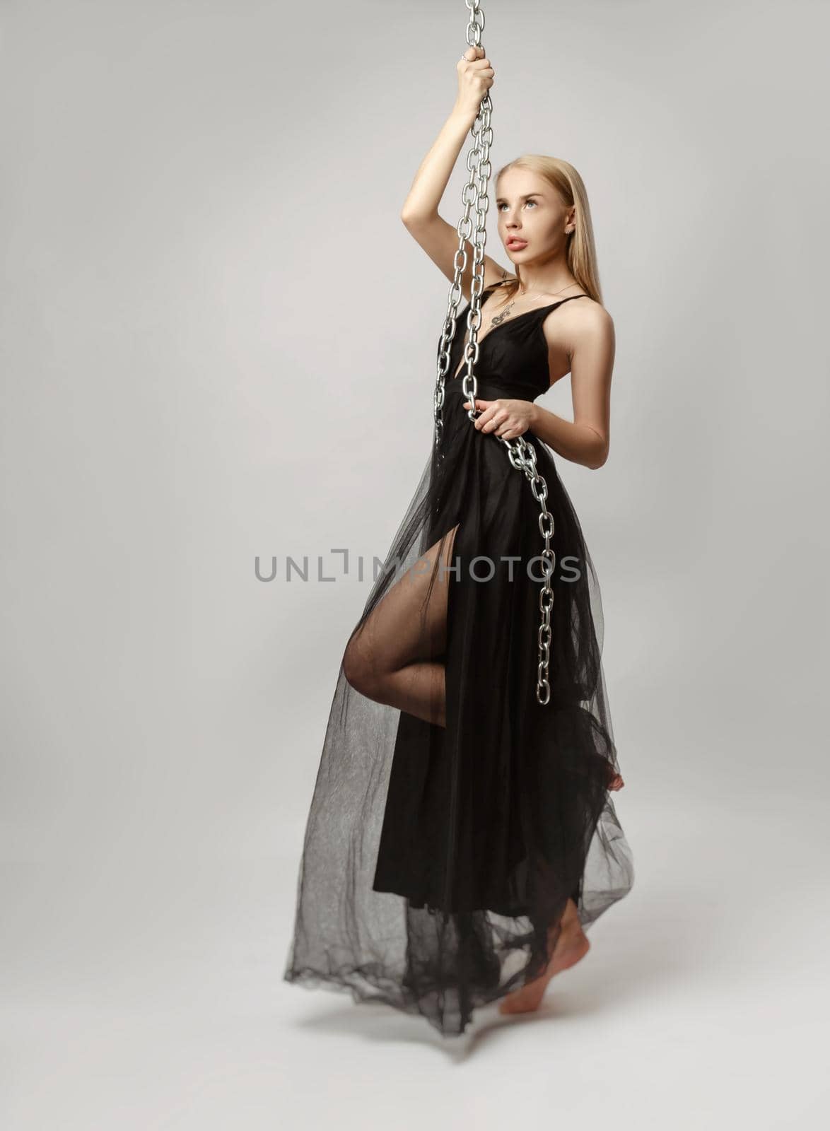 Beautiful blonde in a sexy evening dress on a white background by Rotozey