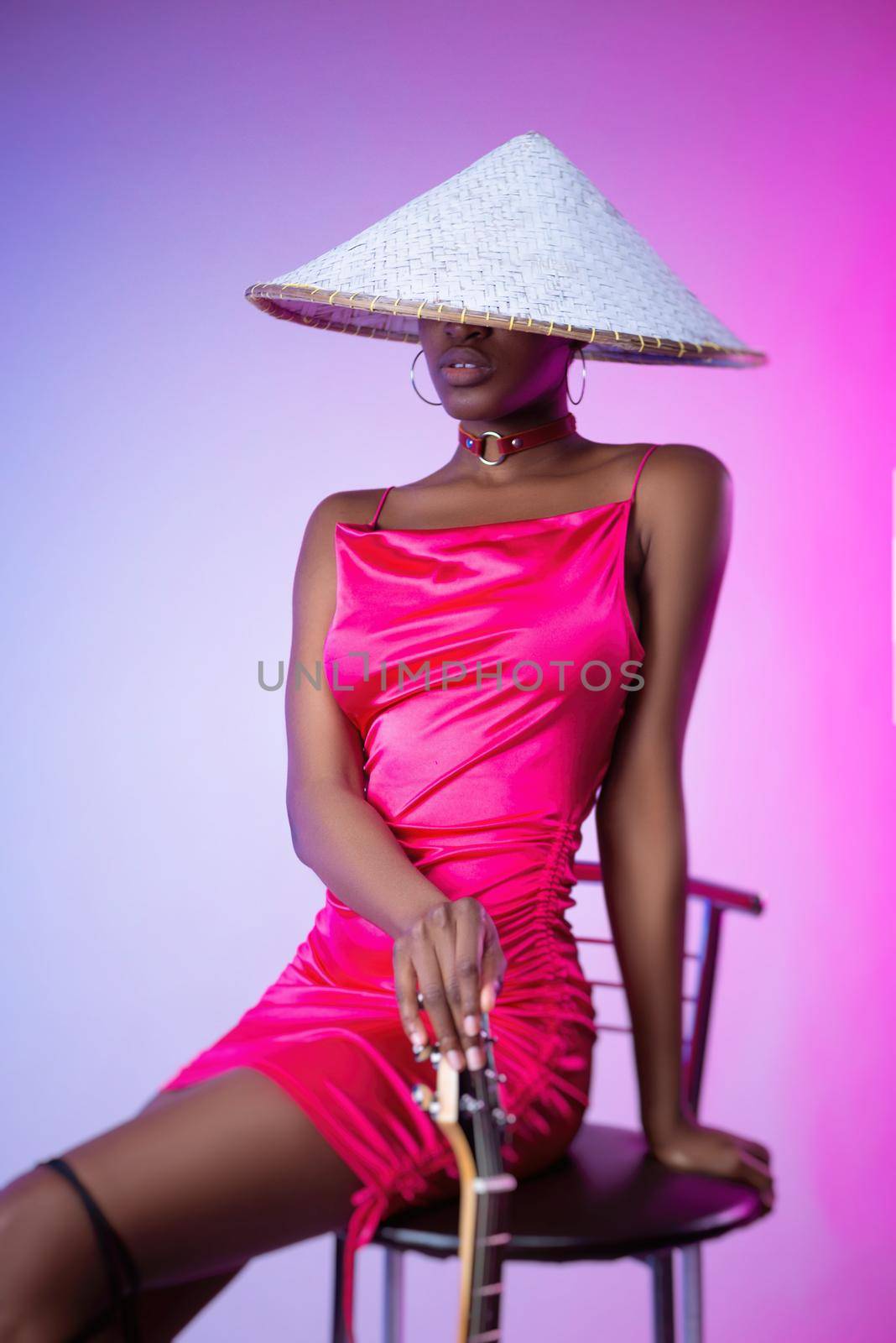 a dark-skinned woman in a pink short dress and a hat with an electric guitar by Rotozey