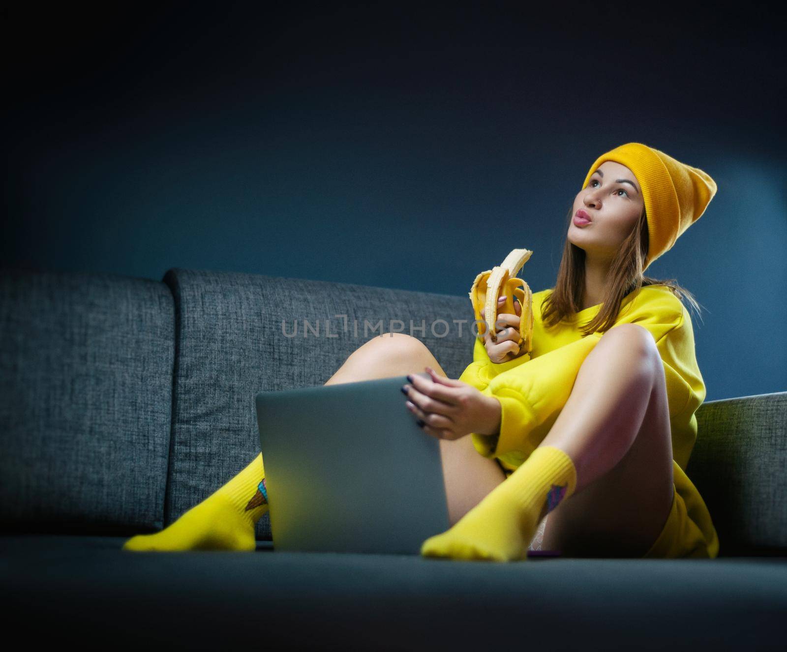 woman on sofa with laptop eating sexy banana by Rotozey
