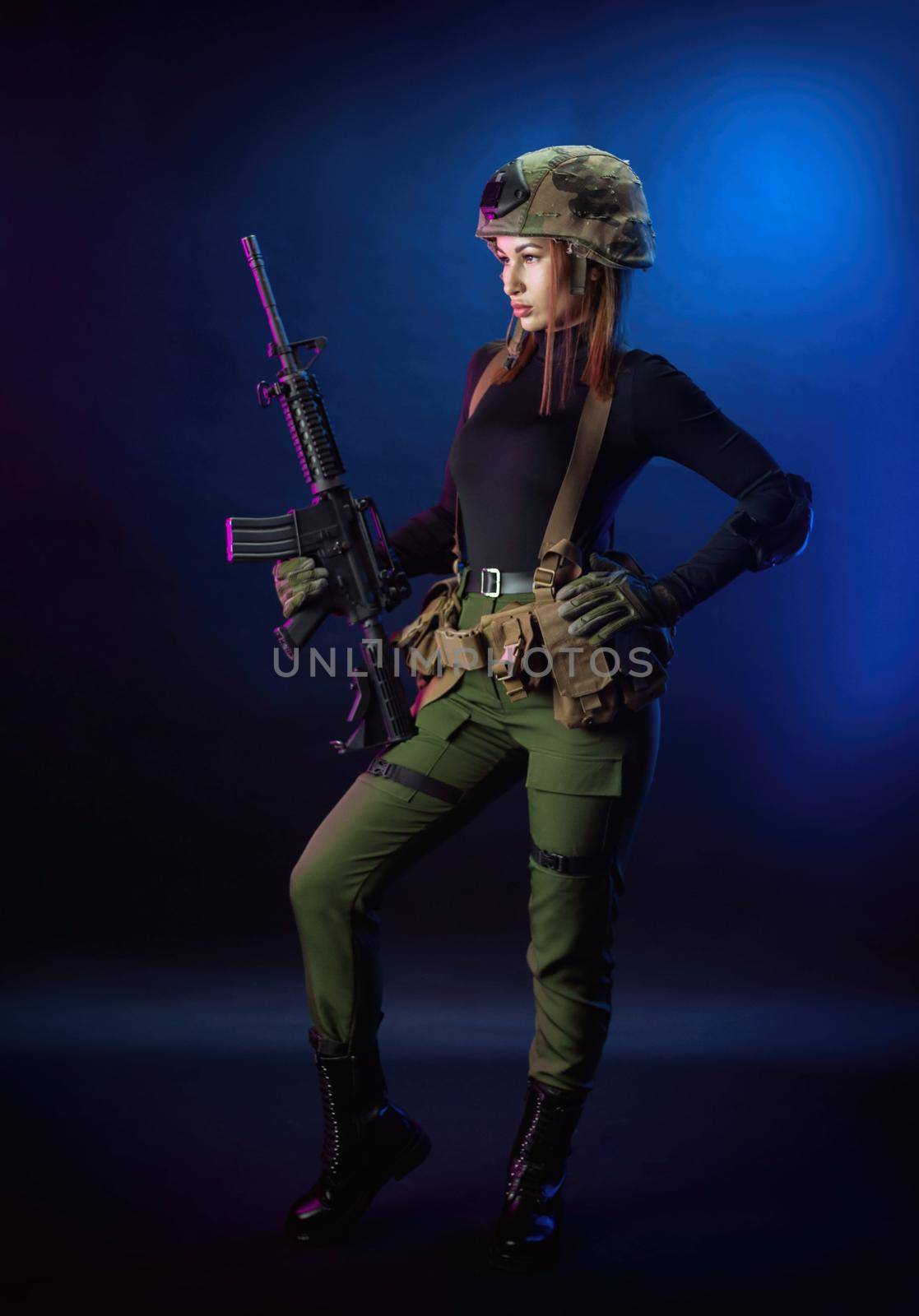 a woman in military airsoft uniform with an American automatic rifle and pistol on a dark background by Rotozey