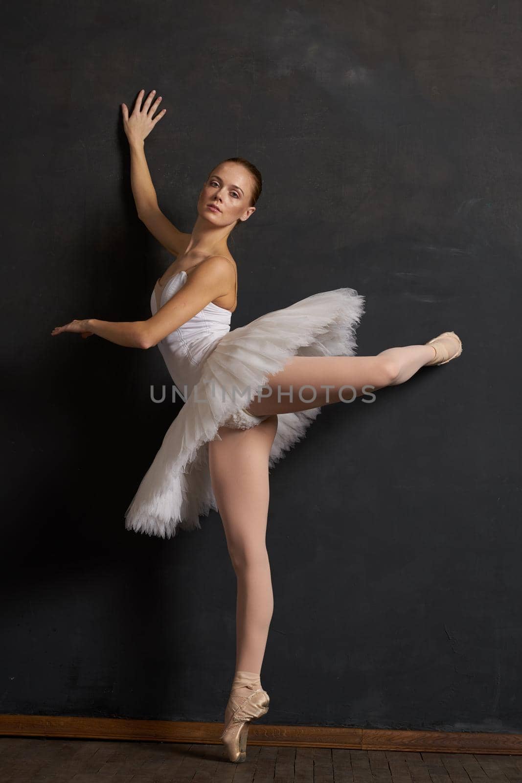 woman ballerina in a white tutu dance posing performance dark background. High quality photo