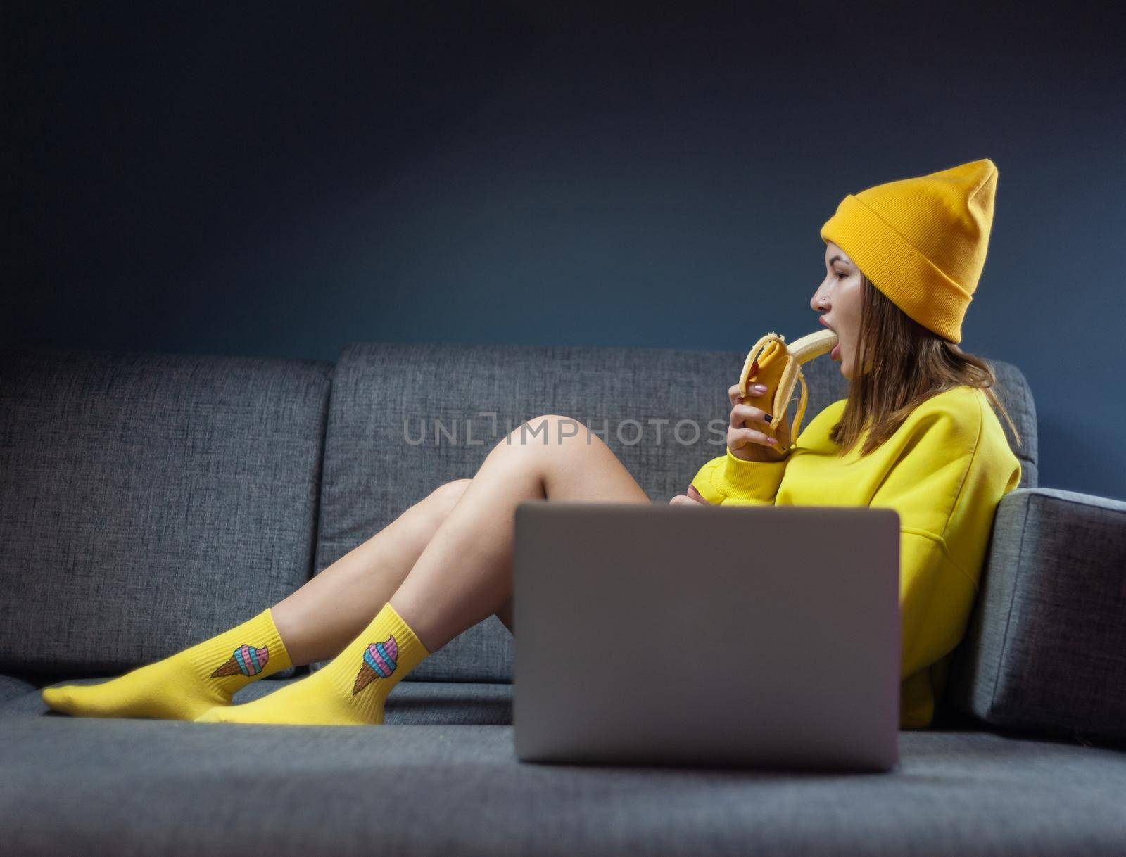 woman on sofa with laptop eating sexy banana by Rotozey