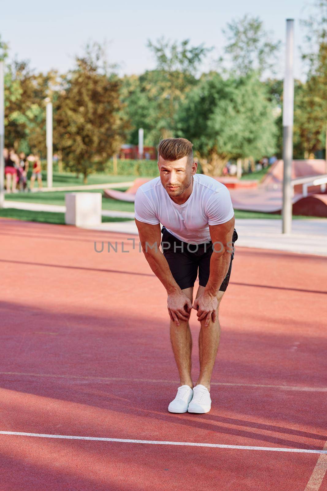 man in white t-shirt on the sports ground workout motivation by Vichizh