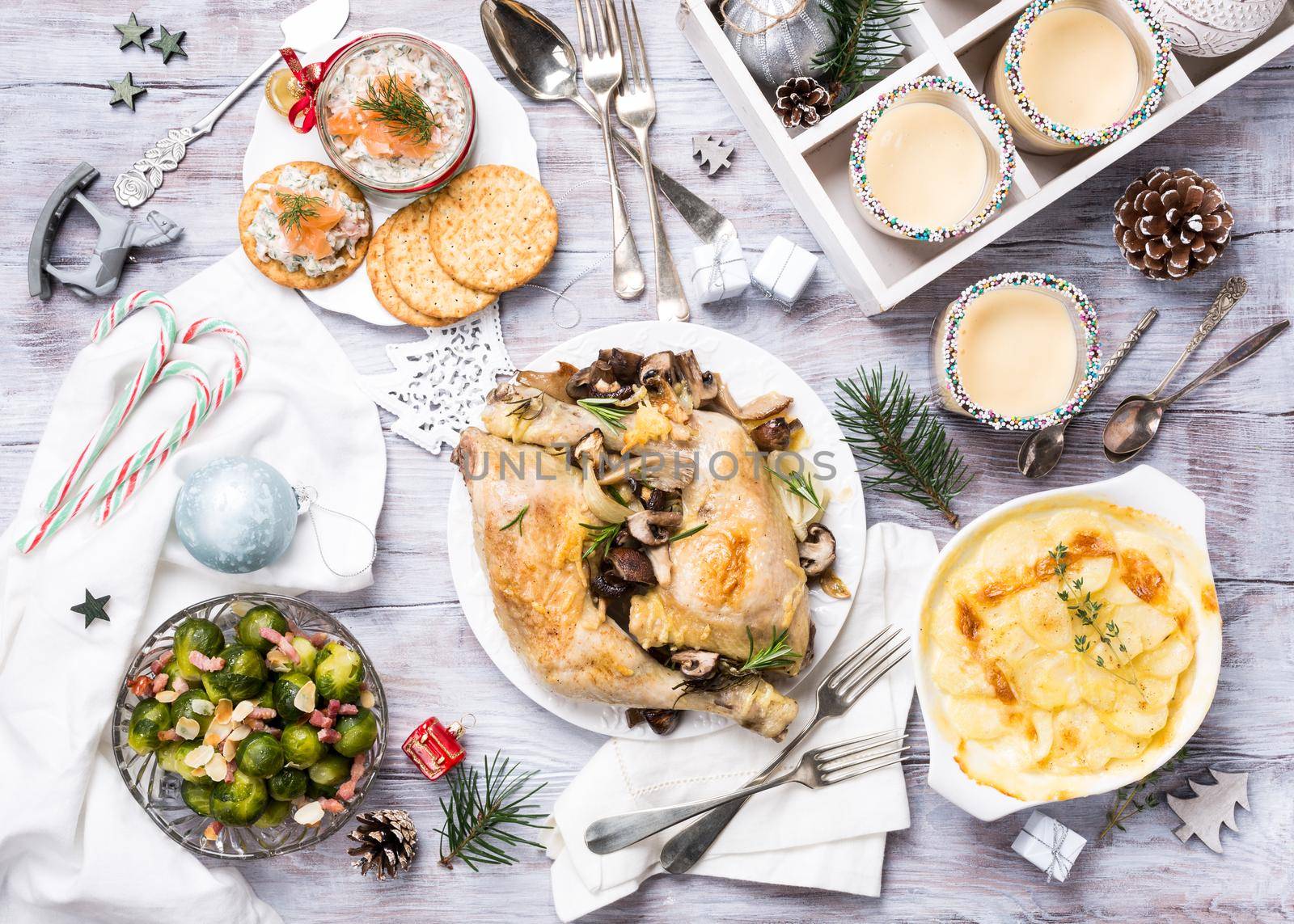 Delicious Christmas themed dinner table with roasted chicken, appetizers and desserts. Top view. Holiday concept.