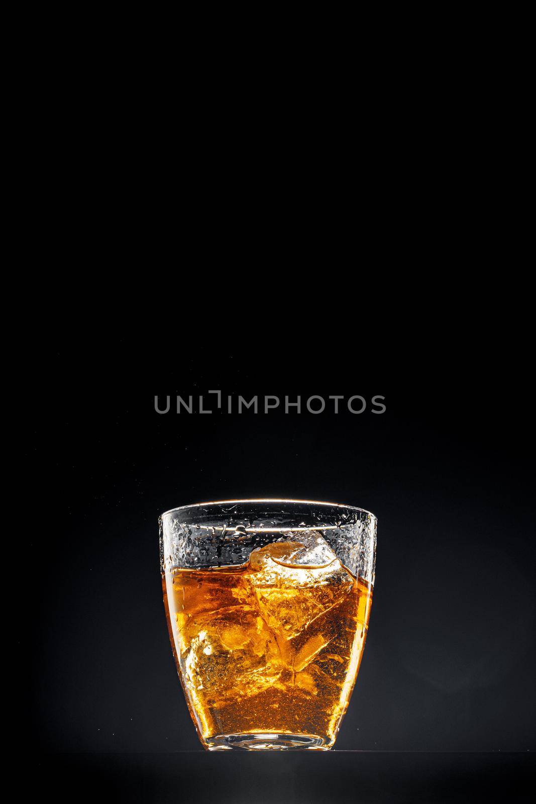 Glass of whisky on black background, copy space by Fabrikasimf