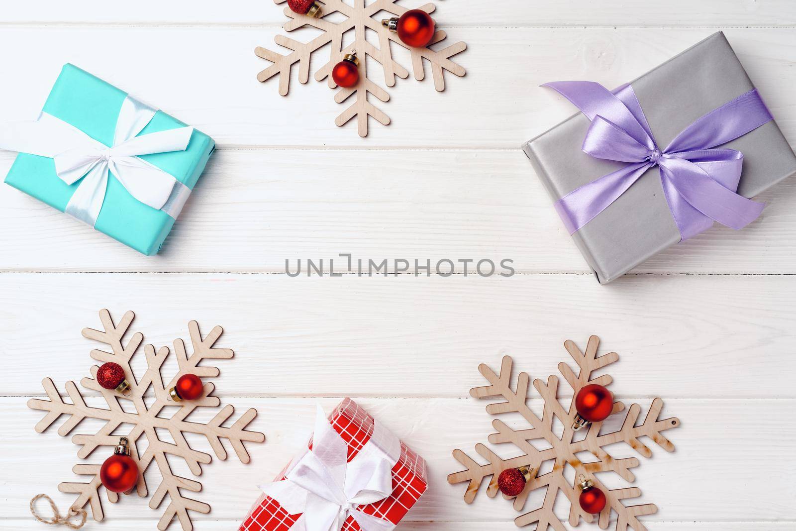 Christmas gifts and decorations on white wooden board, top view
