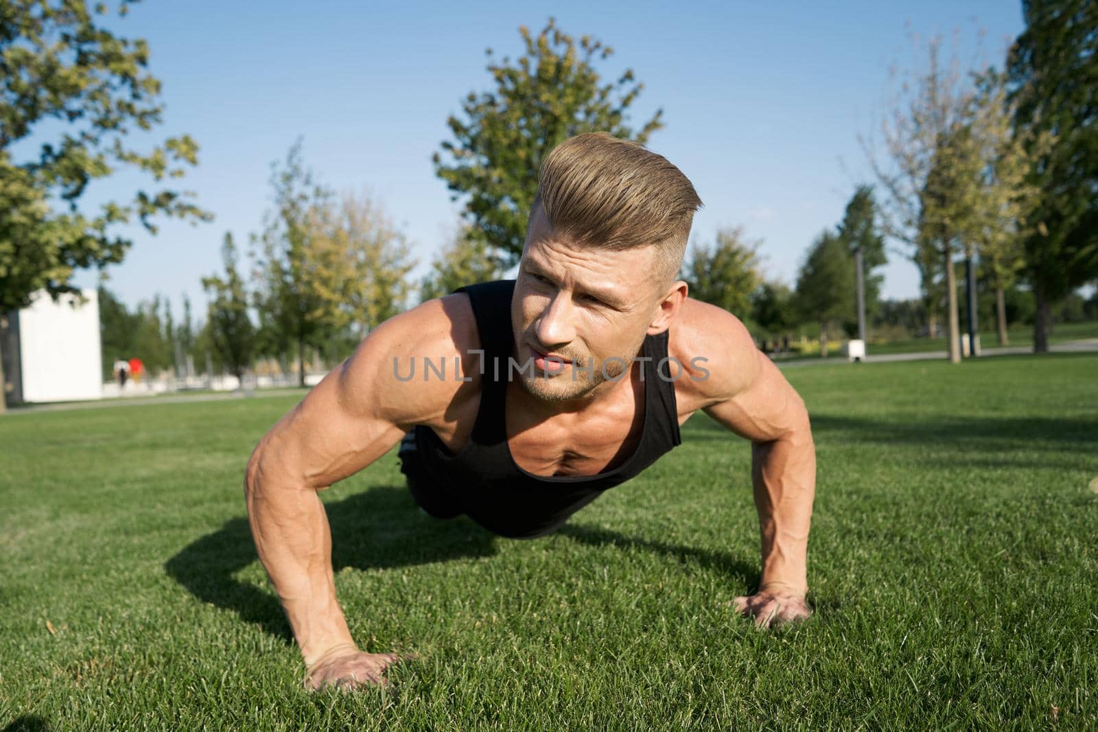athletic man pumped up body in the park workout fitness fresh air by Vichizh