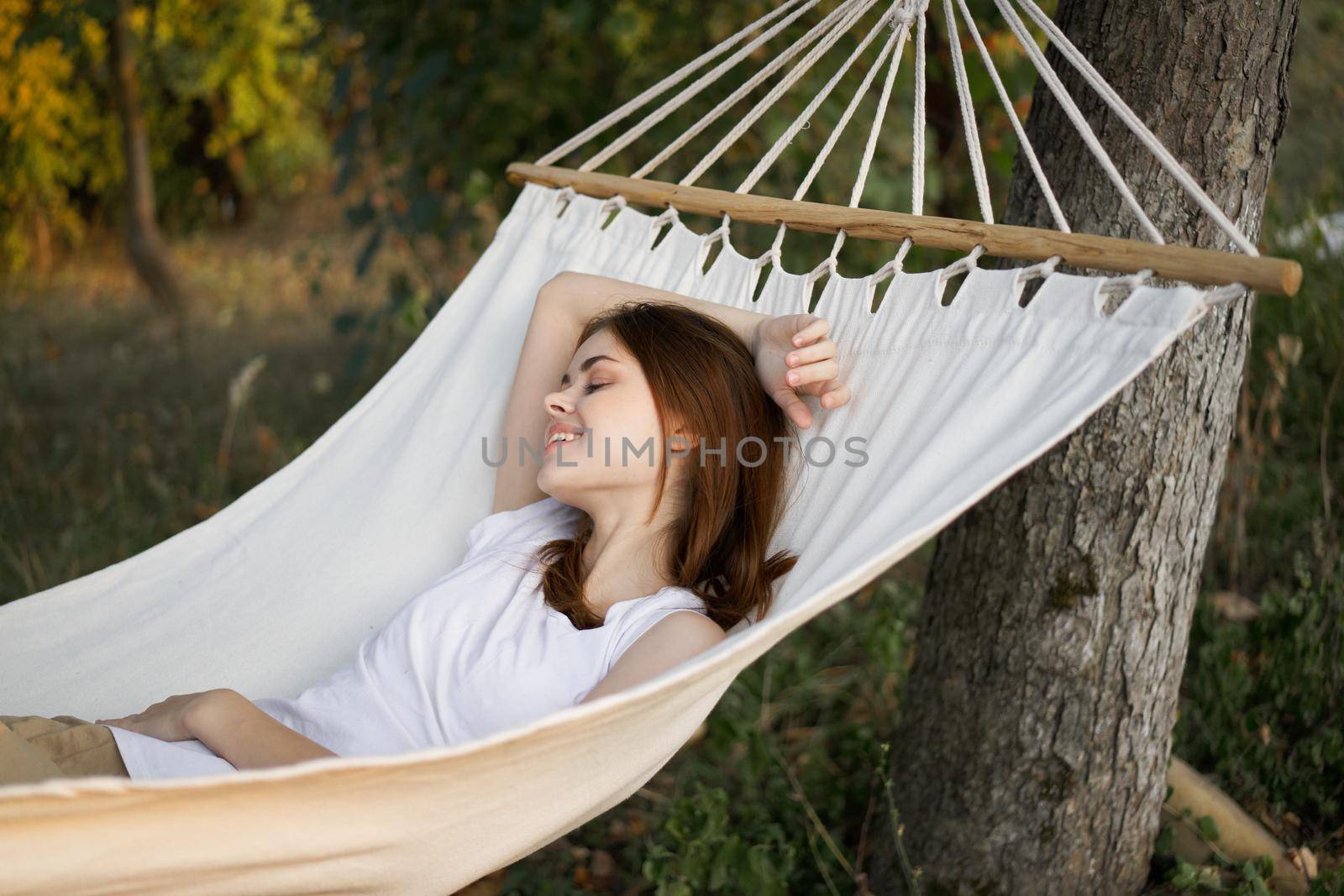 cheerful woman lies in a hammock rest nature fresh air by Vichizh