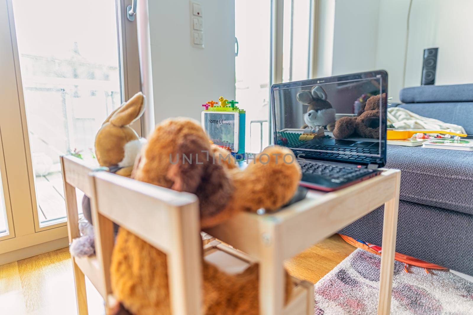 Homeoffice - new working oportunities symbolically shot with an on a notebook working stuffed dog and in front of a toy laptop sitting rabbit, new lifestyle in 2020.