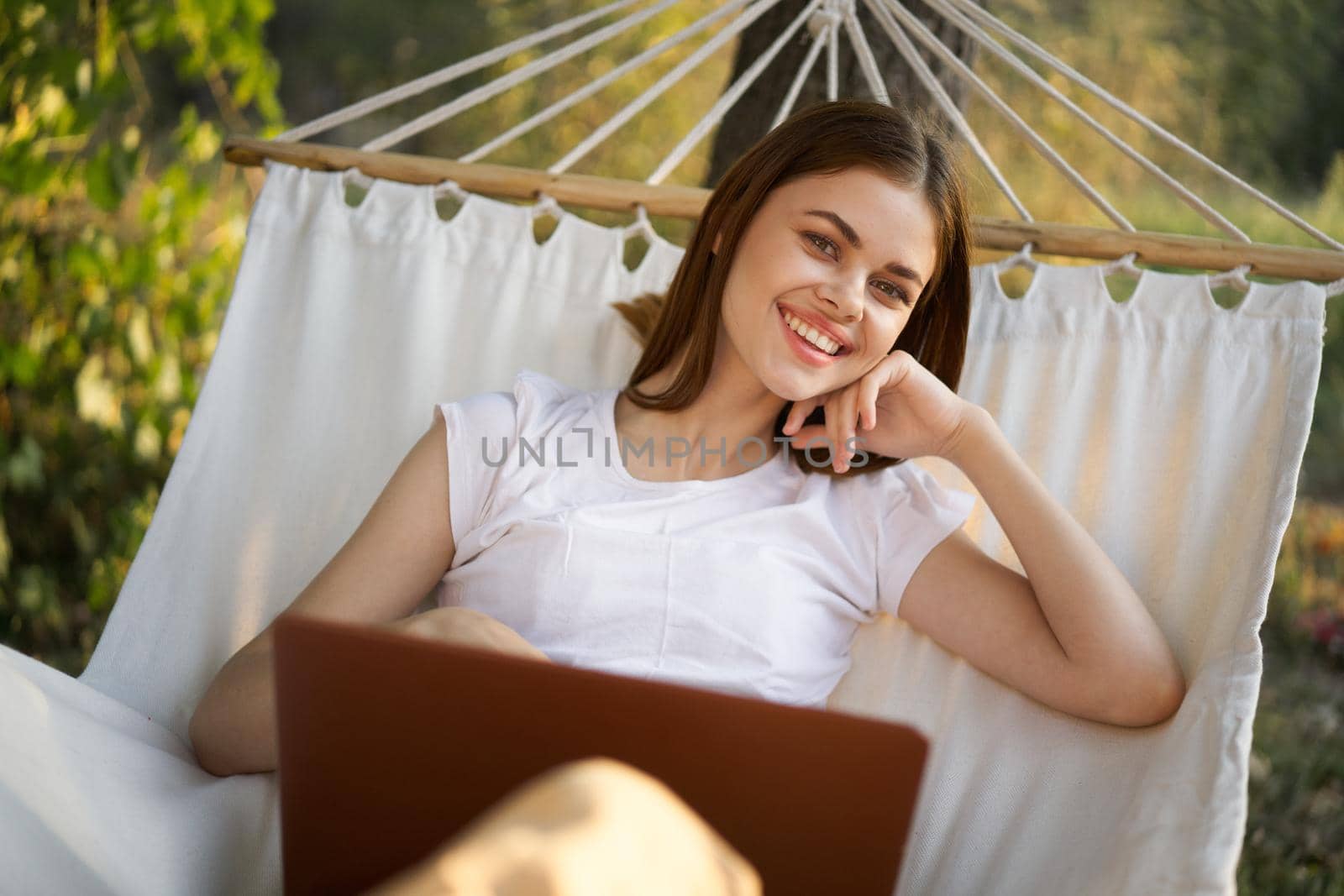 woman working in front of laptop in a hammock in nature. High quality photo