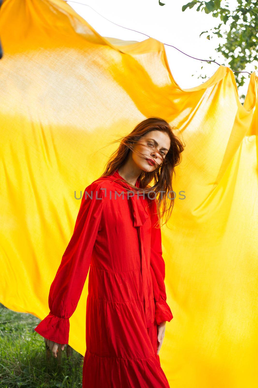 smiling woman in red dress posing yellow background. High quality photo