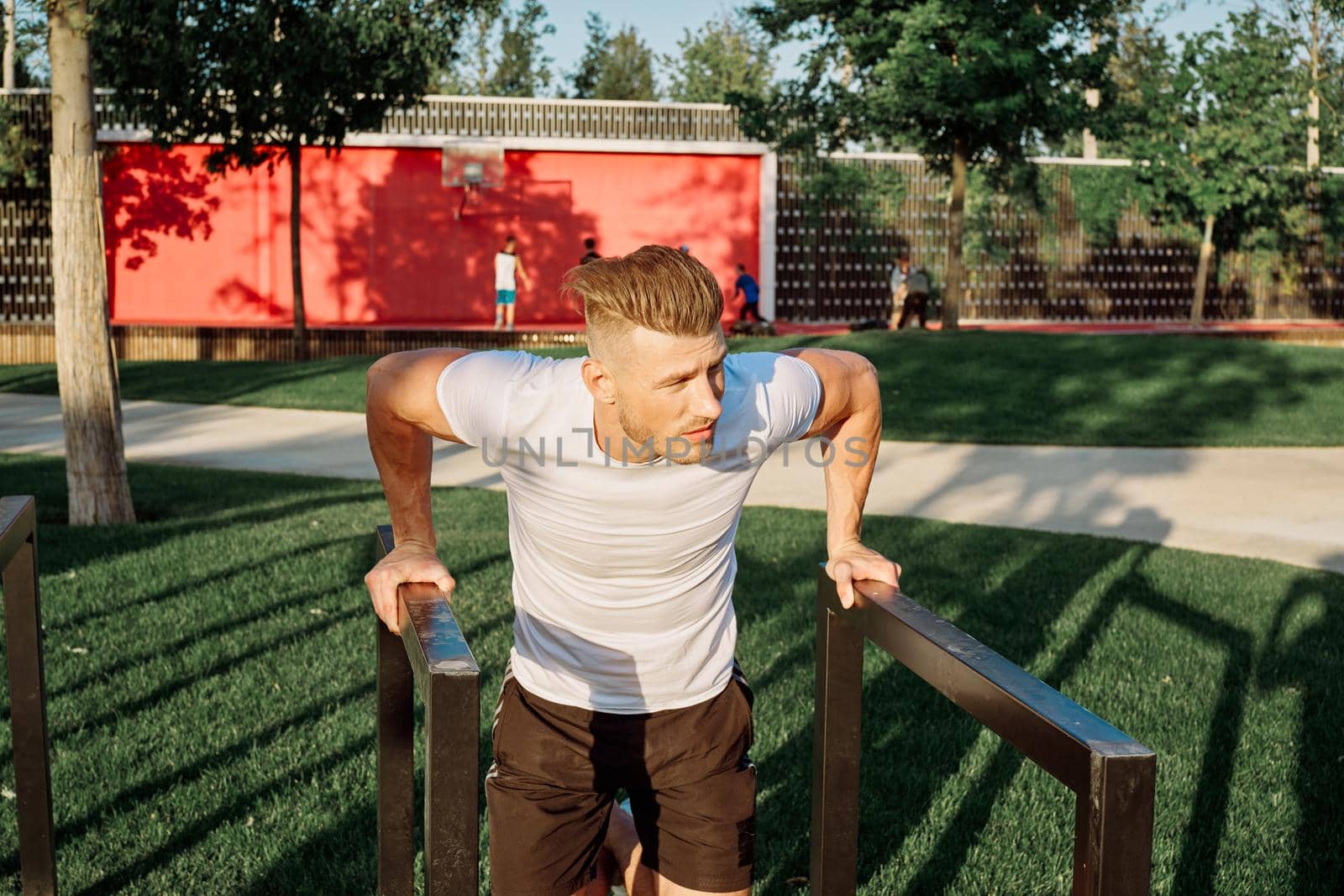 athletic man with dumbbells outdoors at CrossFit park by Vichizh