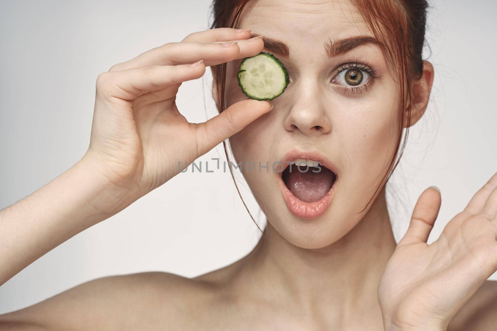 attractive woman with bare shoulders cucumber skin care health. High quality photo