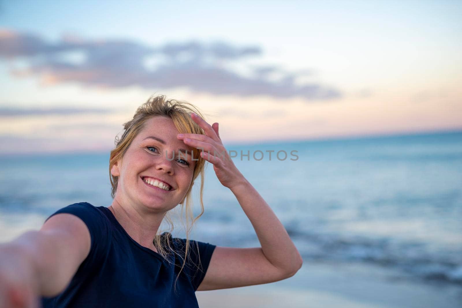 Follow me - happy young woman pulling guy's hand - hand in hand walking at sunset seaside - concept of carefree modern life by Alexxoma