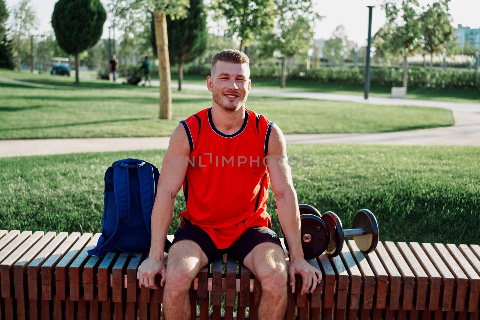 athletic man in red t-shirt in fitness park. High quality photo