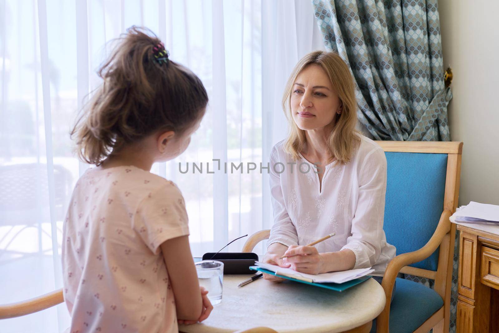 Child girl at session with social worker, school psychologist in office by VH-studio