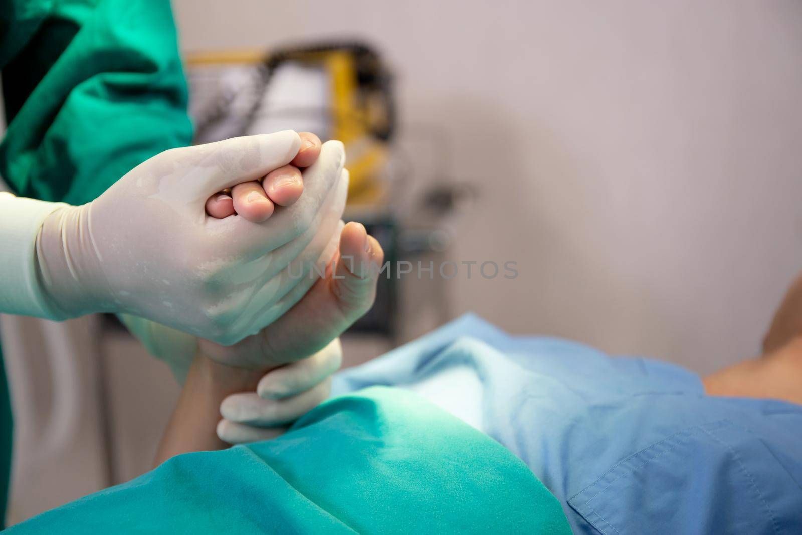 Hands of doctor holding with patient for encourage and trust at hospital, surgeon encouragement patient before surgery for healing with emergency in the operation room, medical and health concepts.