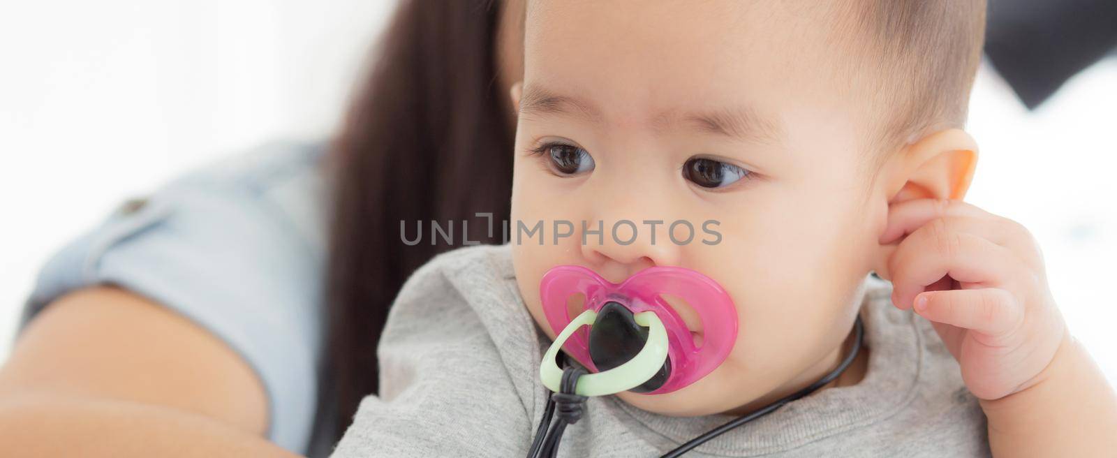 Closeup portrait of asian newborn, happiness face little baby girl with innocent, eyes of infant with feeling positive and cheerful, health and care, childcare and cozy. by nnudoo