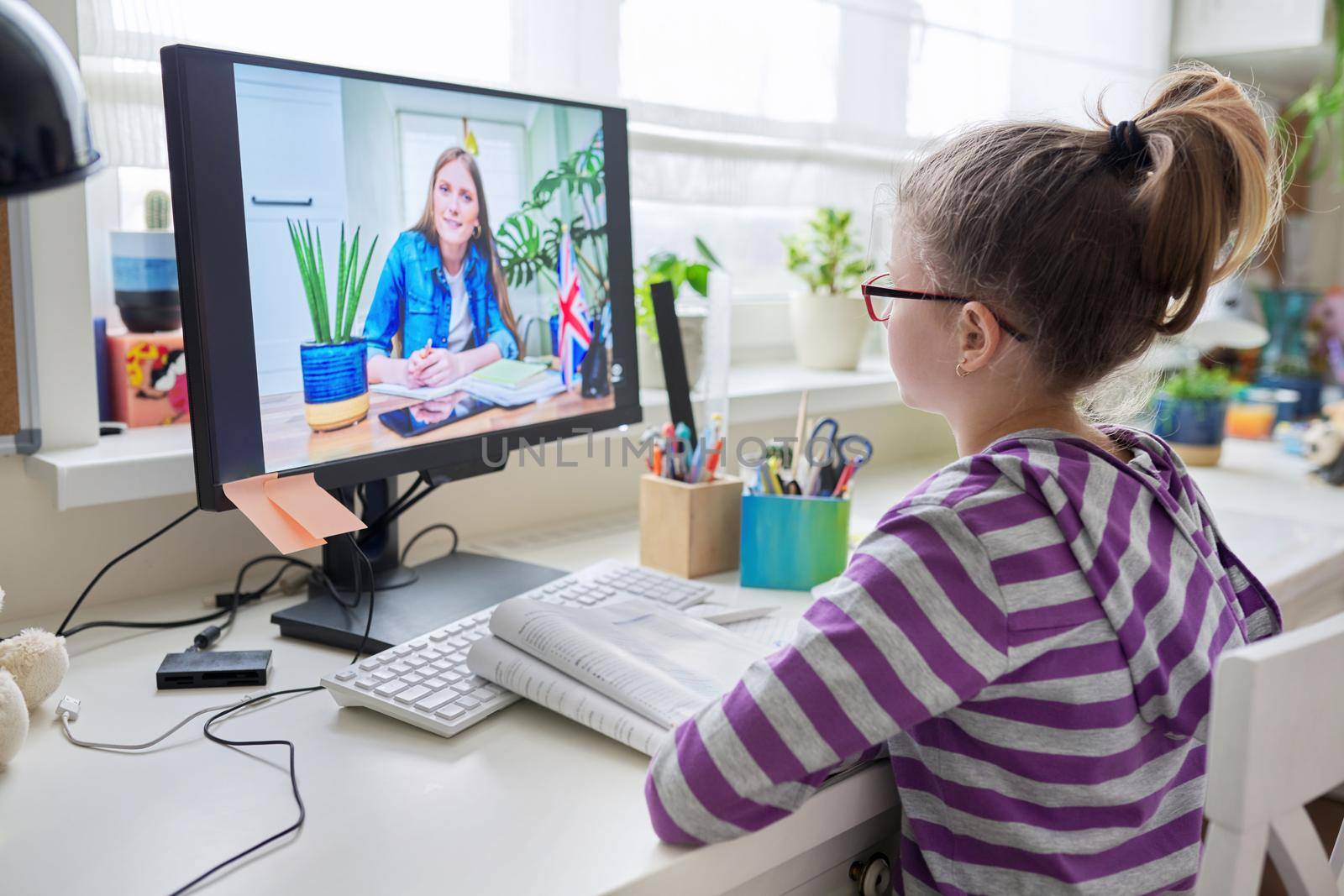 Online learning, children, little student girl learning language remotely with an English teacher. E-education, modern technologies in education, school concept